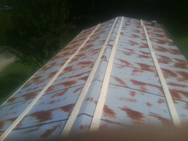 Rusted metal roof panels with new wood purlins before replacement — Storm Damage Roof Repair in Bellville by Roofing Brothers